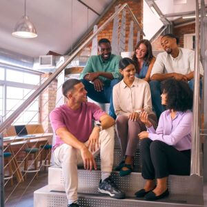 smiling multi cultural business team sitting on stairs