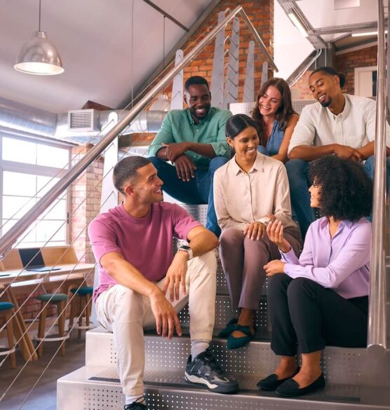 smiling multi cultural business team sitting on stairs
