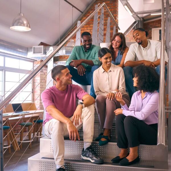 smiling multi cultural business team sitting on stairs